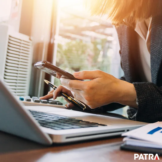business woman using phone and laptop to perform working tasks
