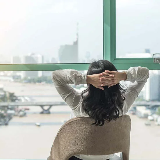 Open Enrollment Woman looking out the window relaxing