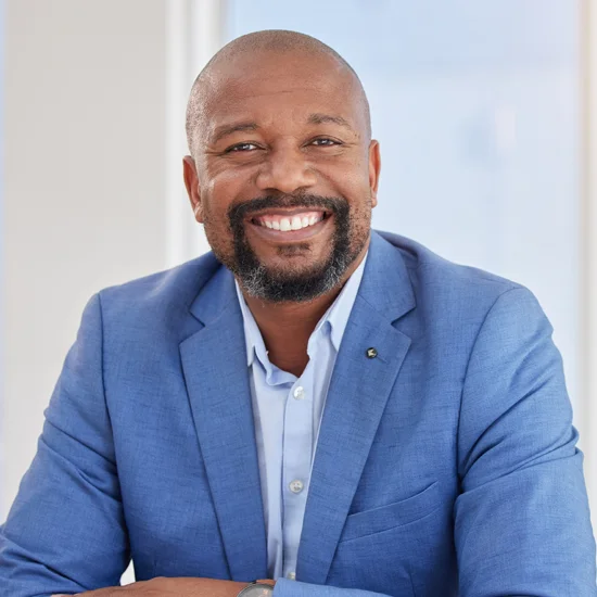 Man wearing a suit, smiling facing the camera