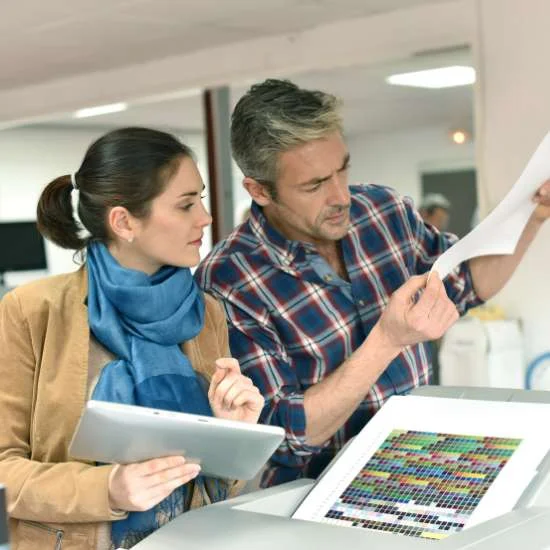 Colleagues reviewing freshly printed documents