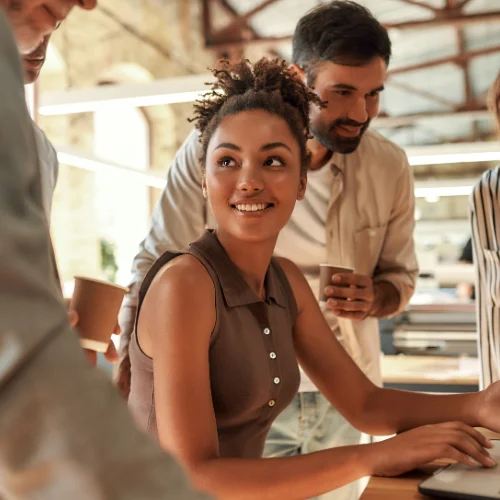 Group of people relaxing while one is on a laptop working