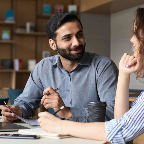 Colleagues conversing at a meeting table