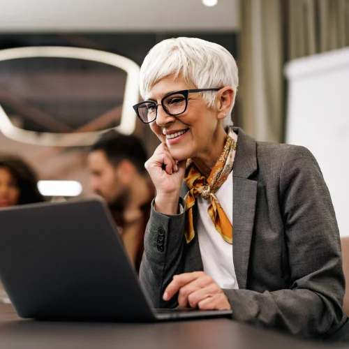 Woman smiling as she reviews information on her laptop