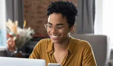 Woman using laptop and phone