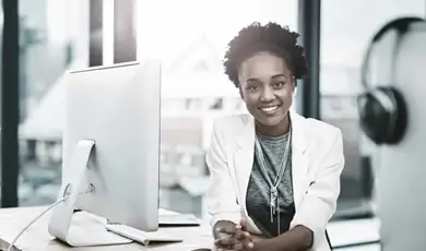 woman smiling in front of computer