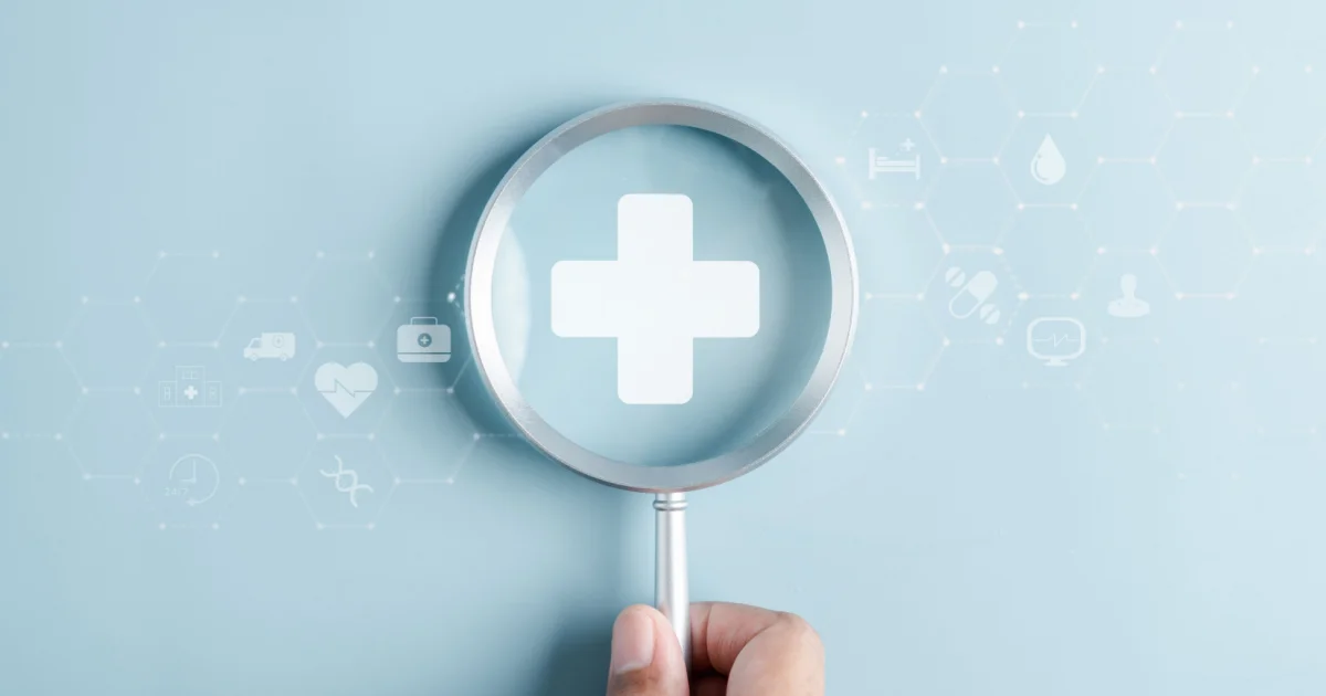 A human hand holding magnifying glass hovering over general health insurance agency logo