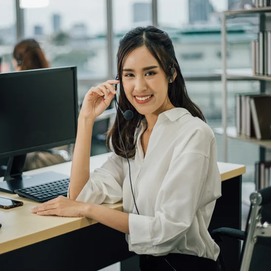 asian woman call center operator with headset looking the camera and smiling
