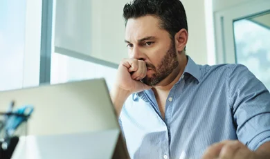 businessman reviewing information on laptop showing worried expression businessman reviewing information on laptop showing worried expression