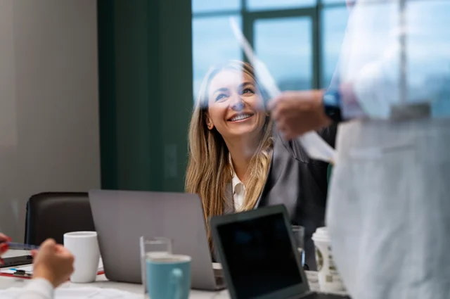 business woman smiling while working with a colleague business woman smiling while working with a colleague