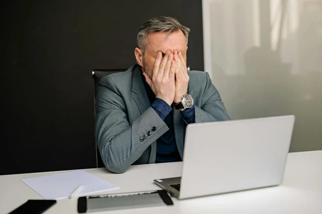 business man with hands covering face in frustration business man with hands covering face in frustration