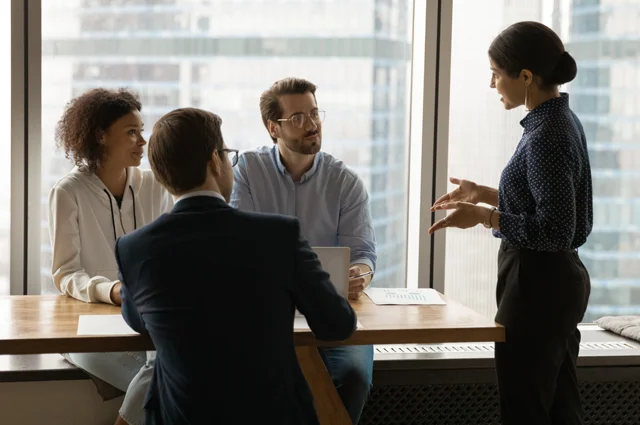 Confident female team leader providing training or guidance to staff