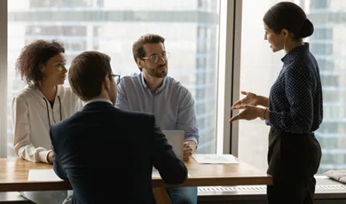 Confident female team leader providing training or guidance to staff