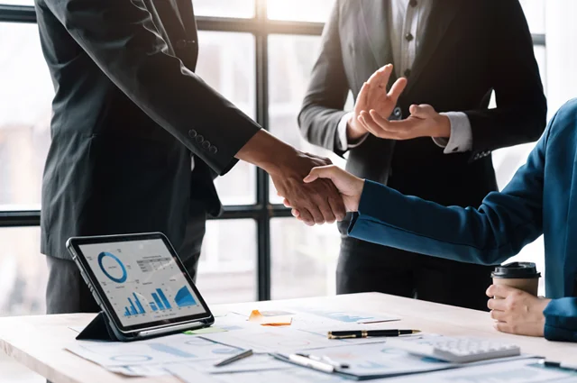 business people shaking hands finishing up meeting business etiquette m&a concept
