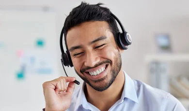 Call center agent, smiling, while talking on a headset