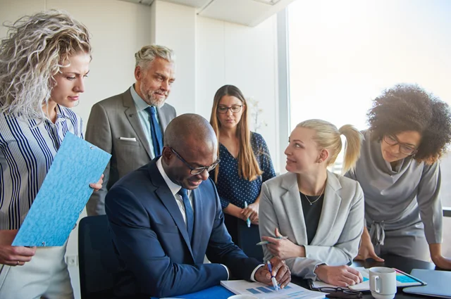diverse group of businesspeople discussing paperwork