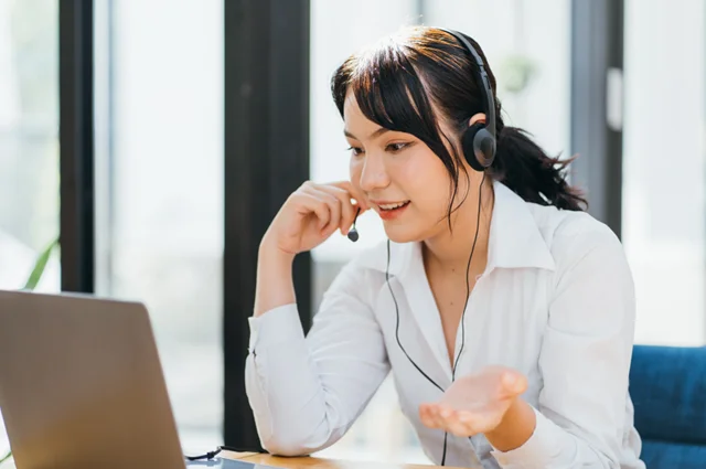 young friendly operator woman agent with headsets working in a call centre