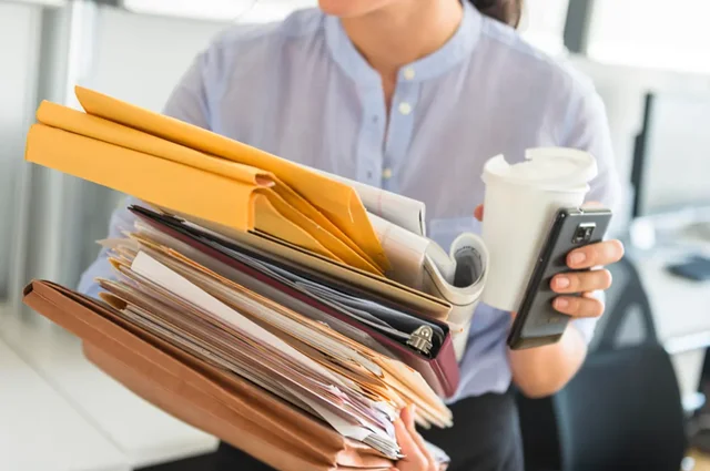 inefficient business woman holding stack