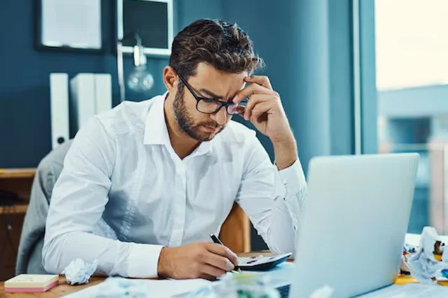 inefficient young businessman looking stressed out while working
