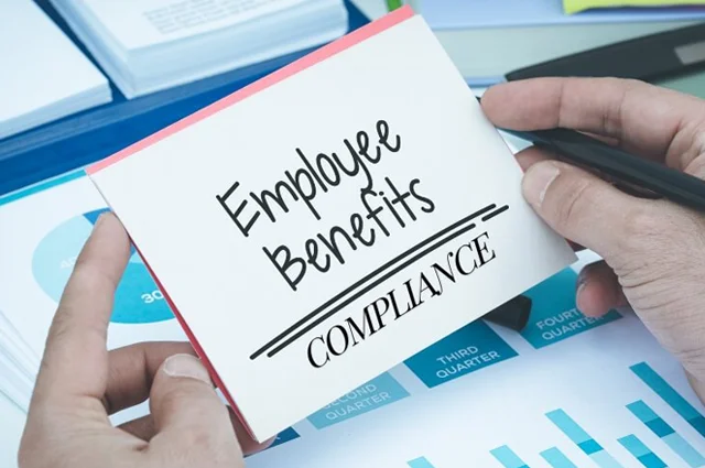 Hand holding card about employee benefits compliance
