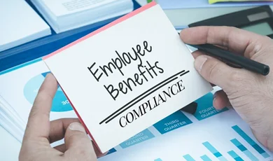 Hand holding card about employee benefits compliance