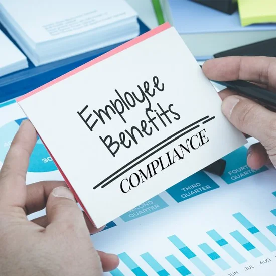 Hand holding card about employee benefits compliance