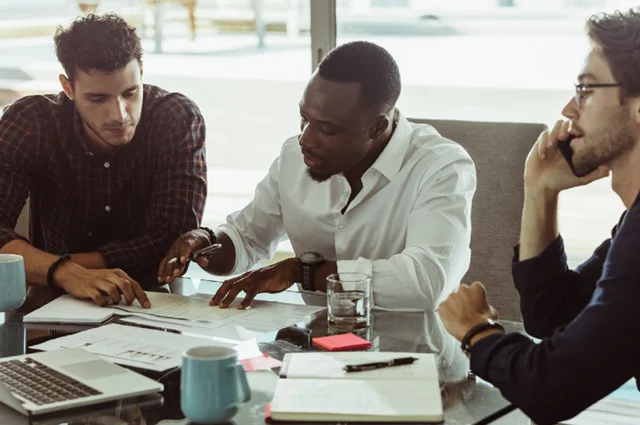 colleagues reviewing documents together with papers and laptops